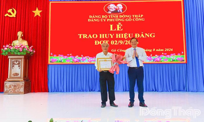 Đồng chí Nguyễn Hữu Lợi, Tỉnh ủy viên, Bí thư Đảng ủy, Chủ tịch HĐND phường Gò Công, trao Huy hiệu 35 năm tuổi Đảng cho đảng viên tại địa phương.