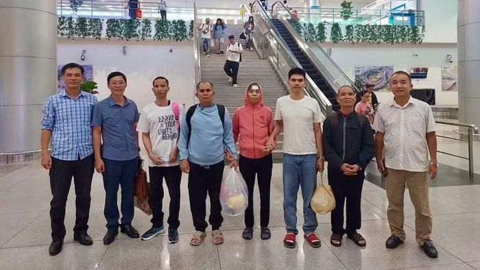 Cơ quan Công an hỗ trợ 5 người hồi hương từ Thái Lan (thứ 2 đến thứ 6 từ trái sang) được nhập cảnh, trở về địa phương an toàn. Ảnh: T.T