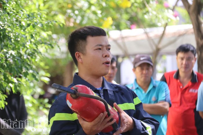 Cán bộ chữa cháy hướng dẫn cách sử dụng bình chữa cháy xách tay.