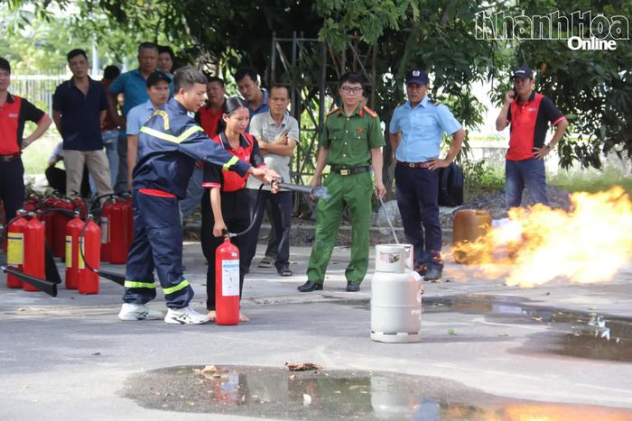 Học viên được hướng dẫn thực hành dùng bình chữa cháy dập lửa do rò rỉ khí gas.