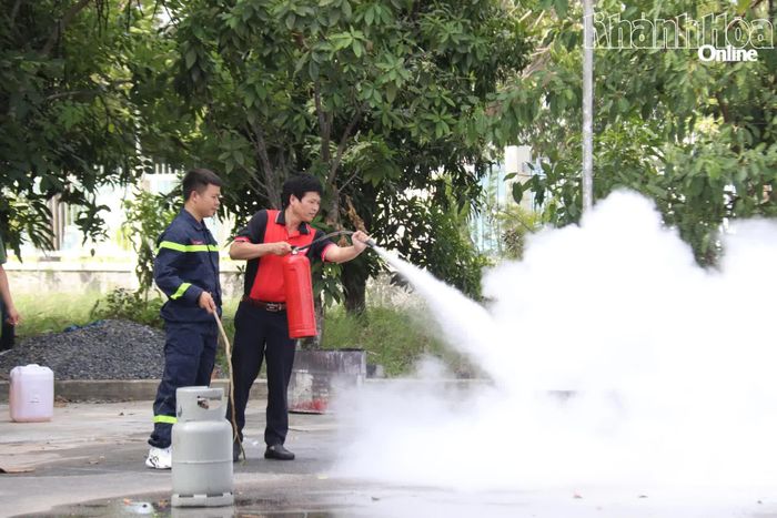 Học viên thực hành kỹ năng sử dụng bình chữa cháy xách tay để dập lửa khay xăng.