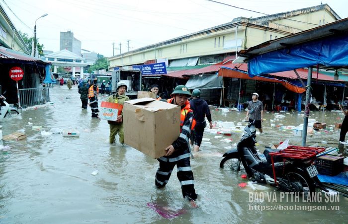 Lực lượng chức năng hỗ trợ các hộ kinh doanh tại chợ Giếng Vuông di chuyển hàng hóa đến nơi an toàn