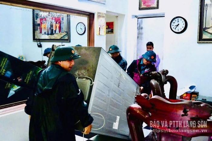 Lực lượng dân quân tự vệ xã Na Sầm hỗ trợ người dân di chuyển đồ ra khỏi nhà bị ngập lụt
