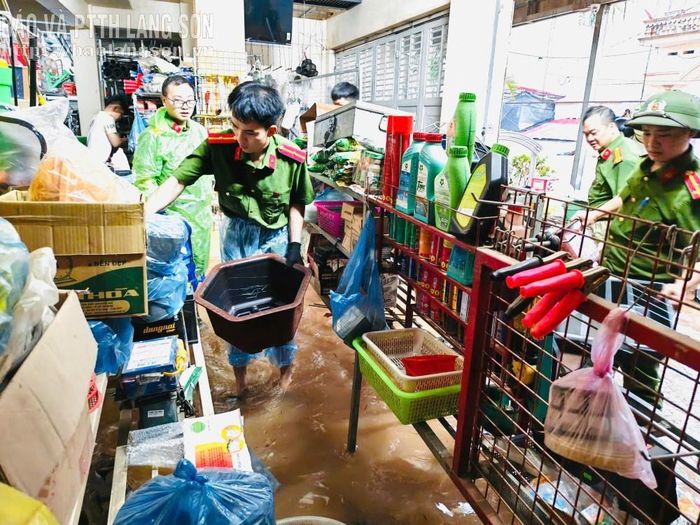 Lực lượng công an xã Na Sầm hỗ trợ tiểu thương di chuyển tài sản ra khỏi khu vực ngập lụt