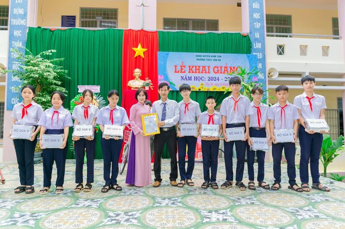 Các em học sinh nhận quà tặng bộ sách giáo khoa của anh Đoàn Minh Tấn nhân dịp khai giảng năm học