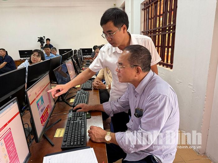 Cán bộ Phòng Văn hóa xã hướng dẫn các cán bộ thôn khai thác thông tin trên Trang thông tin điện tử của xã.