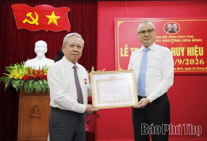 Đồng chí Bí thư Tỉnh ủy Phạm Đại Dương trao Huy hiệu 35 tuổi Đảng cho đồng chí Bùi Văn Tỉnh.