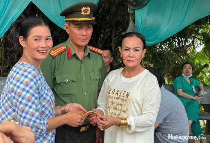 Bà Nguyễn Thị Thu Vân (áo trắng) nhận lại chiếc lắc vàng bị thất lạc. Ảnh: Công an TP. Huế