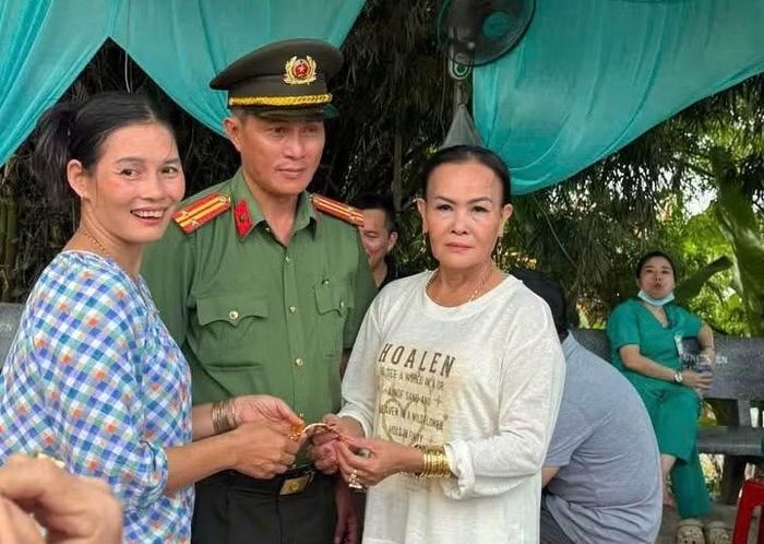 Bà Nguyễn Thị Thu Vân (áo trắng) nhận lại lắc vàng sau khi đánh rơi tại lễ hội điện Huệ Nam.