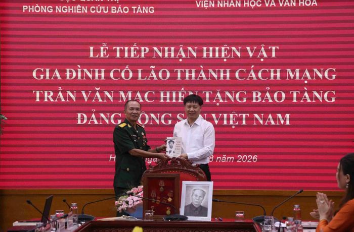 GS.TS Phạm Văn Dương, đại diện Bảo tàng Đảng Cộng sản Việt Nam tiếp nhận hiện vật của đồng chí Trần Văn Mạc từ Ban tổ chức hội thảo.