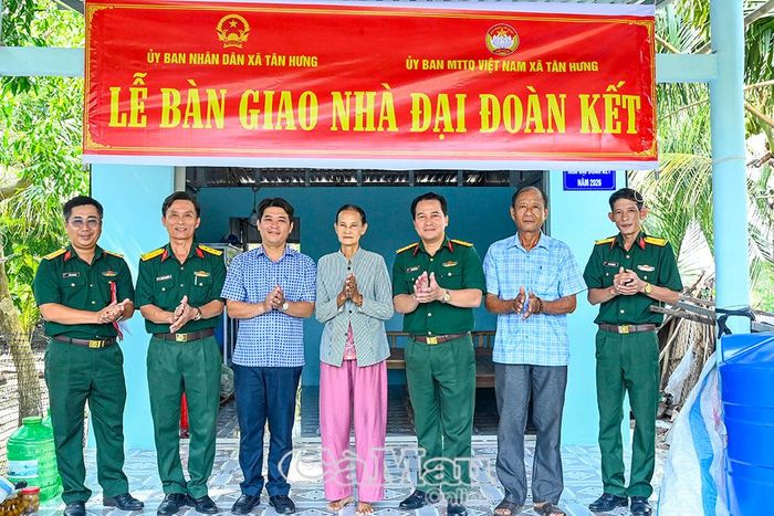 Thủ trưởng Bộ CHQS tỉnh Cà Mau, đại diện cấp uỷ, chính quyền xã Tân Hưng chụp ảnh lưu niệm cùng bà Nguyễn Thị Nhanh tại căn nhà mới.