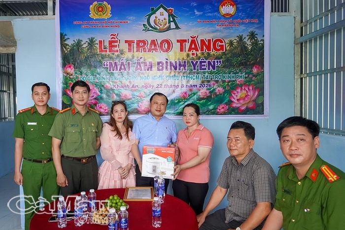 Thượng tá Nguyễn Ty Phô, Trưởng Công an xã Bình Hưng, Thành phố Hồ Chí Minh (thứ tư từ trái sang), trao phần quà đến gia đình bà Nguyễn Hồng Dô.