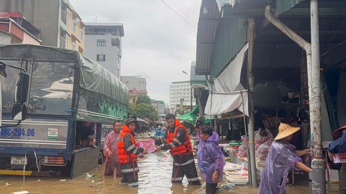 Ngoài lực lượng chức năng như Quân đội, Công an... phường Kỳ Lừa huy động công chức cơ sở tham gia ứng cứu hàng hóa cho tiểu thương chợ Giếng Vuông. (Ảnh: Công an Lạng Sơn)