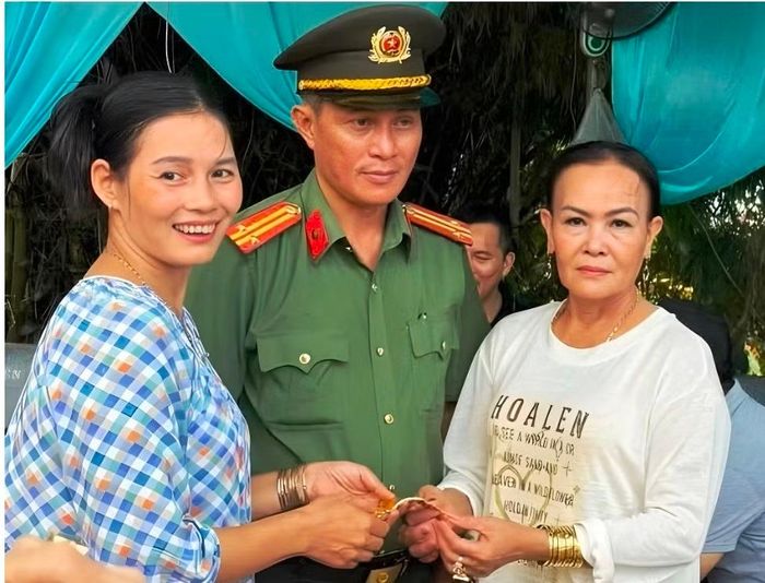 Du khách Nguyễn Thị Thu Vân (phải) nhận lại lắc vàng trọng lượng 1 cây đánh rơi tại lễ hội điện Huệ Nam. (Ảnh CACC)