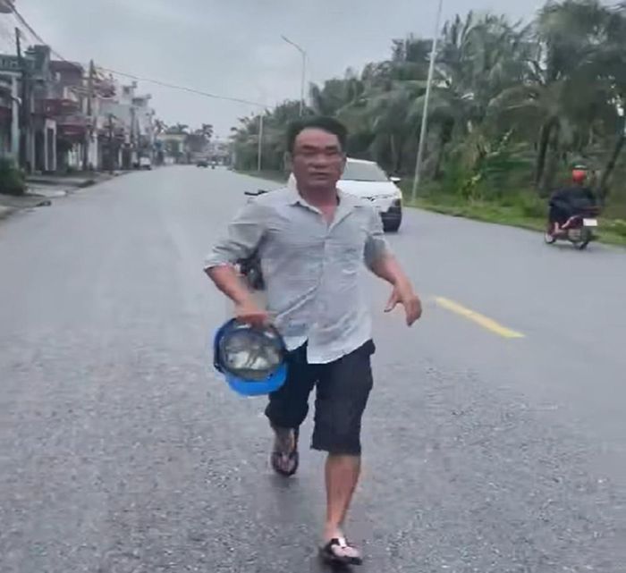 Người đàn ông hùng hổ cẩm mũ bảo hiểm chạy lại đánh tài xế ô tô. (Ảnh cắt từ clip)