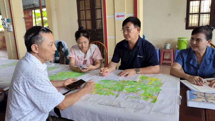 Cán bộ tổ công tác giải thích tận tình cho người dân hiểu về “Chiến dịch 45 ngày” hoàn thành cơ sở dữ liệu đất đai. Ảnh: PV