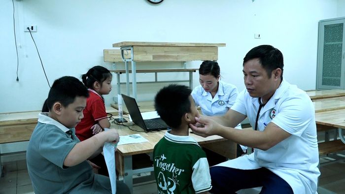 Cán bộ, nhân viên y tế khám sức khỏe cho học sinh trường Tiểu học Mỹ Đức A. Ảnh: Biên Phạm