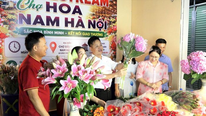 Phó Bí thư Đảng ủy, Chủ tịch UBND xã Bình Minh Nguyễn Đăng Việt cùng cơ sở kinh doanh hoa lên sóng livestream quảng bá, giới thiệu sản phẩm. Ảnh T. Đạt
