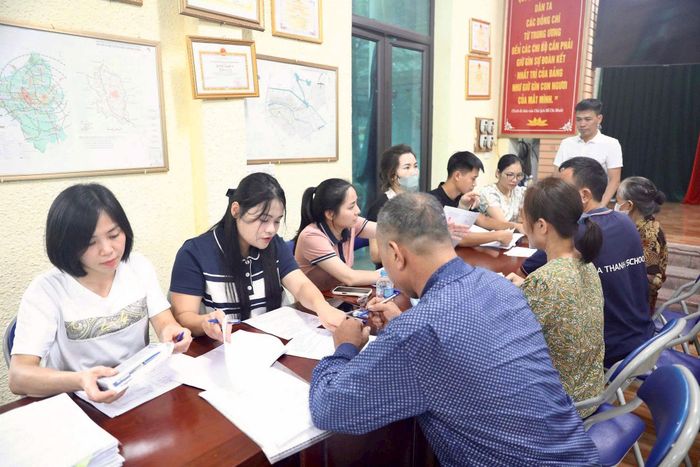Người dân làm thủ tục nhận tiền bồi thường, hỗ trợ theo quy định. Ảnh: NS