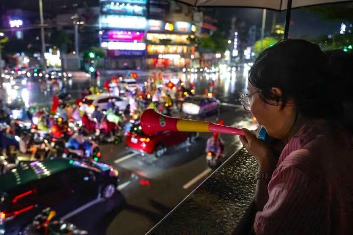 Tiếng kèn cổ vũ vang lên hòa nhịp cùng tiếng còi xe rộn rã phía dưới mặt đường.