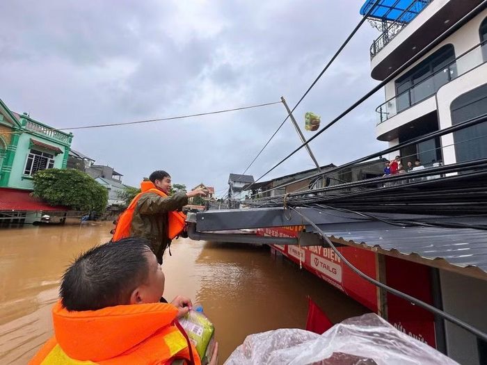 Nhu yếu phẩm được trao đến các hộ dân bị cô lập bởi mưa lũ