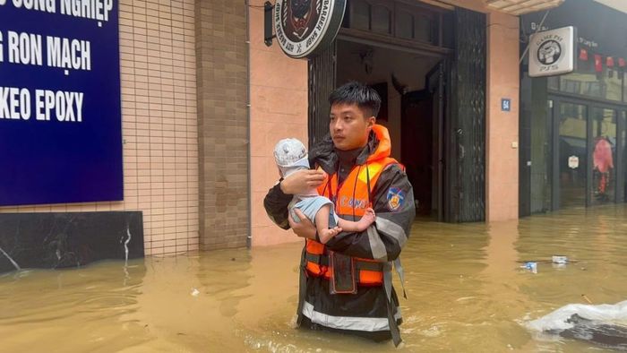 Cán bộ, chiến sĩ Phòng Cảnh sát cơ động hỗ trợ đưa trẻ nhỏ ra khỏi khu vực ngập sâu