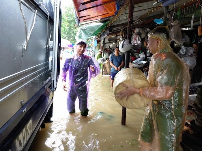 Cán bộ Công an phường Đông Kinh hỗ trợ người dân di chuyển tài sản khỏi khu vực ngập úng tại chợ Giếng Vuông