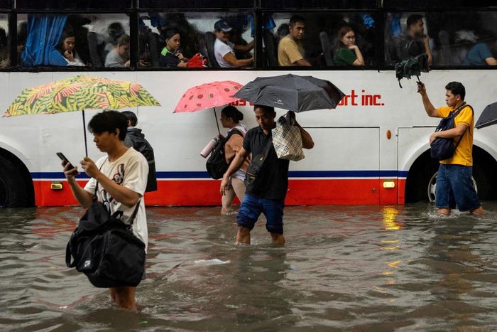  Người dân lội qua dòng nước ngập trên đường phố Manila (Philippines) ngày 17/8, khi mưa lớn do gió mùa trút xuống thủ đô, gây ngập úng trên diện rộng và làm gián đoạn sinh hoạt của người dân. 