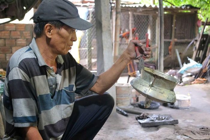 Ông Đỗ Đức Cảm bên phôi đồng thô được lấy ra khỏi khuôn