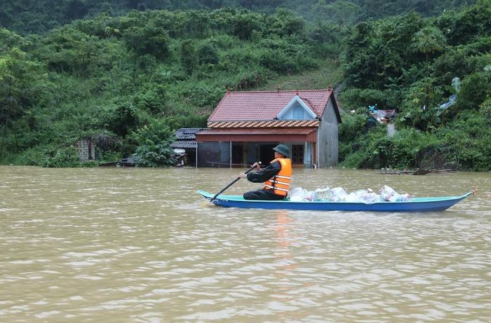 Dùng thuyền chuyển quà cứu trợ khẩn cấp vào vùng cô lập ở xã Tân Đoàn, tỉnh Lạng Sơn. Ảnh: Anh Tuấn – TTXVN