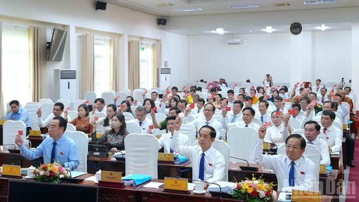 Các đại biểu Hội đồng nhân dân tỉnh Cà Mau tại kỳ họp thứ 5 (chuyên đề) biểu quyết thông qua Nghị quyết quy định chính sách miễn phí sách giáo khoa cho học sinh. (Ảnh: HỮU TÙNG)