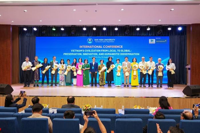  Đại diện Trường đại học Văn Hiến tặng hoa và chụp ảnh lưu niệm cùng các học giả, chuyên gia. ﻿(Ảnh: Trường đại học Văn Hiến) 