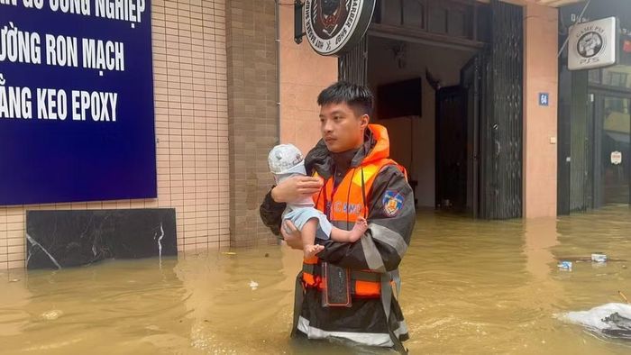 Chiến sĩ Công an di chuyển cháu bé sơ sinh đến nơi an toàn. (Ảnh: Hùng Chu)