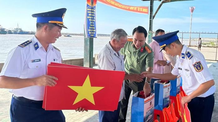 Lực lượng chức năng trao cờ, tặng quà cho ngư dân tỉnh Lâm Đồng. (ẢNH: KIỀU KIỀU)
