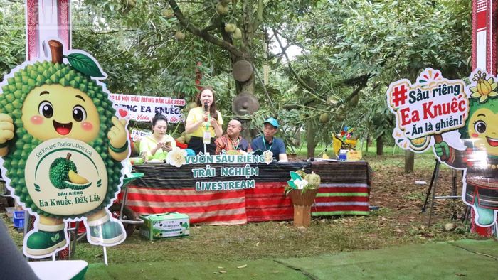 Bí thư Đảng ủy, Chủ tịch Hội đồng nhân dân xã Ea Kuếc Ngô Thị Minh Trinh (người mặc áo vàng cầm micrô) trực tiếp livestream xúc tiến thương mại và bán sầu riêng cho người dân địa phương mình. (Ảnh: Nguyễn Công Lý)