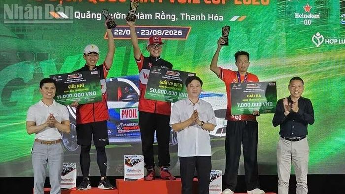 Ban tổ chức trao giải cho các vận động viên Nhất, Nhì, Ba nội dung đua ô-tô hạng cầu trước. (Ảnh: Mai Luận)