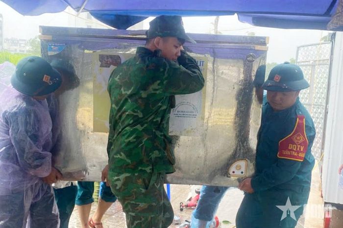 Lực lượng vũ trang phường Móng Cái hỗ trợ nhân dân di chuyển đồ đạc đến nơi an toàn trước tình trạng nước sông Ka Long dâng cao. 