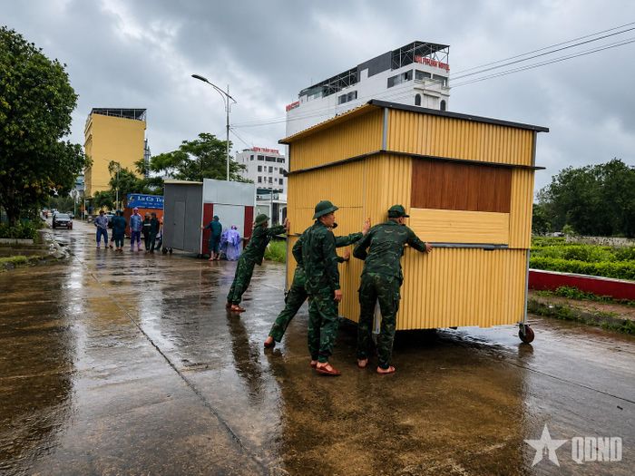 Cán bộ, chiến sĩ Đồn Biên phòng Cửa khẩu quốc tế Móng Cái, Ban chỉ huy Bộ đội Biên phòng tỉnh Quảng Ninh hỗ trợ nhân dân phường Móng Cái 2 di dời tài sản. Ảnh: NGỌC LÂM 