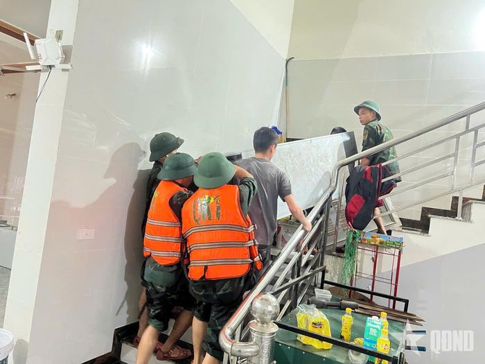 Cán bộ, chiến sĩ Bộ CHQS tỉnh Lạng Sơn giúp đưa tài sản của người dân lên vị trí an toàn.