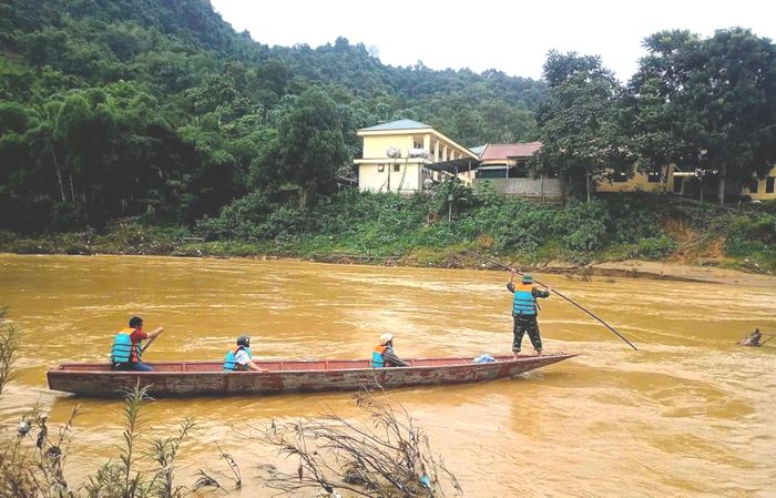 Dùng thuyền chở người dân, hàng hóa qua sông sau khi cầu tạm bị cuốn trôi ở xã Yên Hòa