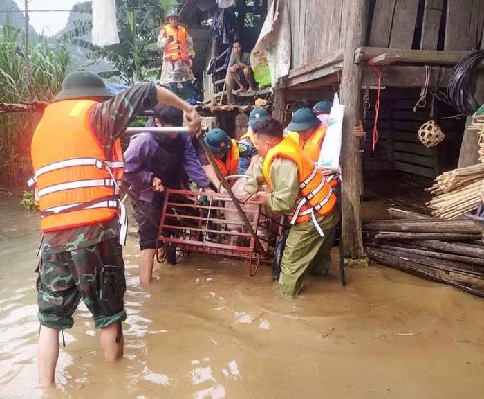 Lực lượng chức năng hỗ trợ người dân xã Bế Văn Đàn di chuyển vật nuôi đến nơi an toàn.