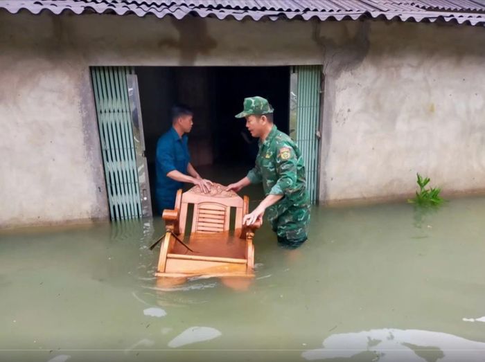 Cán bộ, chiến sĩ Đồn Biên phòng Đức Long, Bộ đội Biên phòng tỉnh Cao Bằng hỗ trợ người dân xóm Nà Lạn, xã Đức Long di chuyển tài sản khỏi khu vực nhà bị ngập do mưa lớn. Ảnh: baocaobang.vn