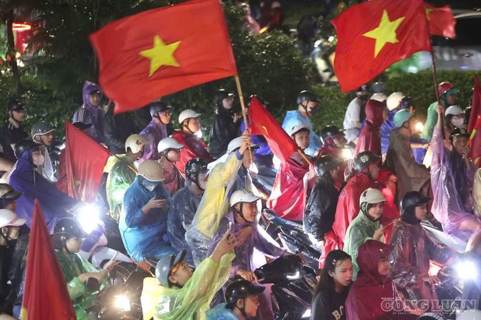 Nhiều cổ động viên mang theo cờ đỏ sao vàng, khoác áo đội tuyển và di chuyển giữa trời mưa để hòa chung không khí mừng chiến thắng.