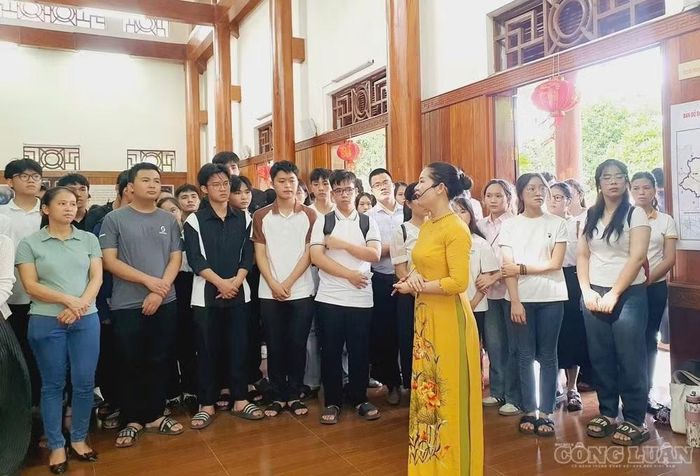 Chị Trần Thị Thu Hằng thuyết minh cho du khách khi đến tham quan nhà lưu niệm Nguyễn Thị Minh Khai. Ảnh: Kim Long