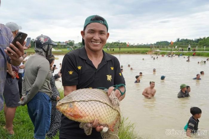 Niềm vui của nơm thủ khi bắt được cá tại lễ hội. Ảnh: Kim Long
