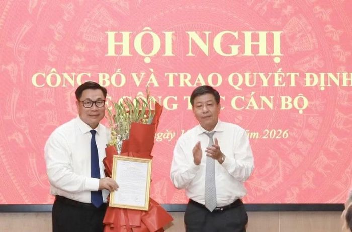 Phó Chủ tịch Thường trực UBND thành phố Dương Đức Tuấn trao quyết định, tặng hoa chúc mừng tân Giám đốc Sở Nội vụ Hà Nội Nguyễn Quang Hiếu. Ảnh: Đình Hiệp