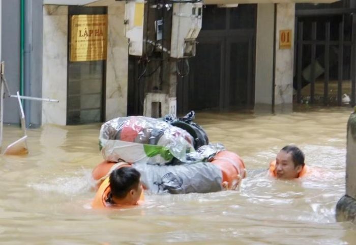 Tại các khu vực nước ngập sâu người dân và lực lượng chức năng phải bơi để di chuyển đồ đạc.