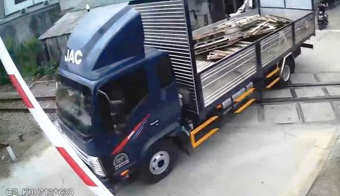 Xe tải vượt qua đường ngang giao với đường sắt tại Huế khi cần chắn phòng vệ đang hạ. Ảnh cắt từ clip camera giám sát.
