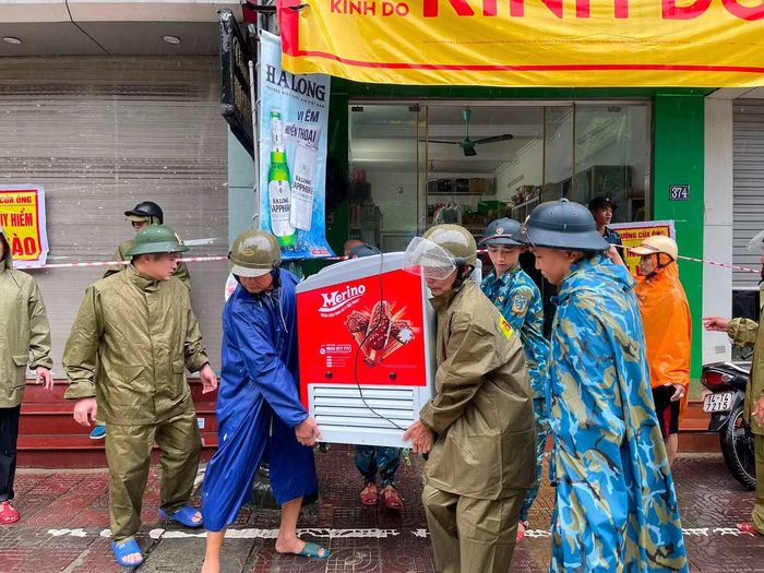 Lực lượng chức năng hỗ trợ người dân di chuyển vật dụng khỏi nơi nguy hiểm.