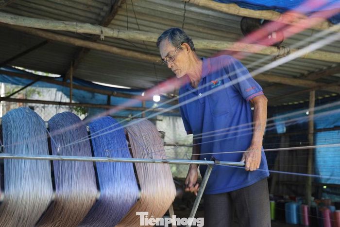 Ông Bùi Phận đã hơn 30 năm gắn bó với nghề xe chỉ. Khoảng 15 năm nay, ông sử dụng máy móc để hỗ trợ công việc. Mỗi kilôgam chỉ xe thành phẩm được trả công khoảng 14.000 đồng. Ảnh: Nguyễn Ngọc
